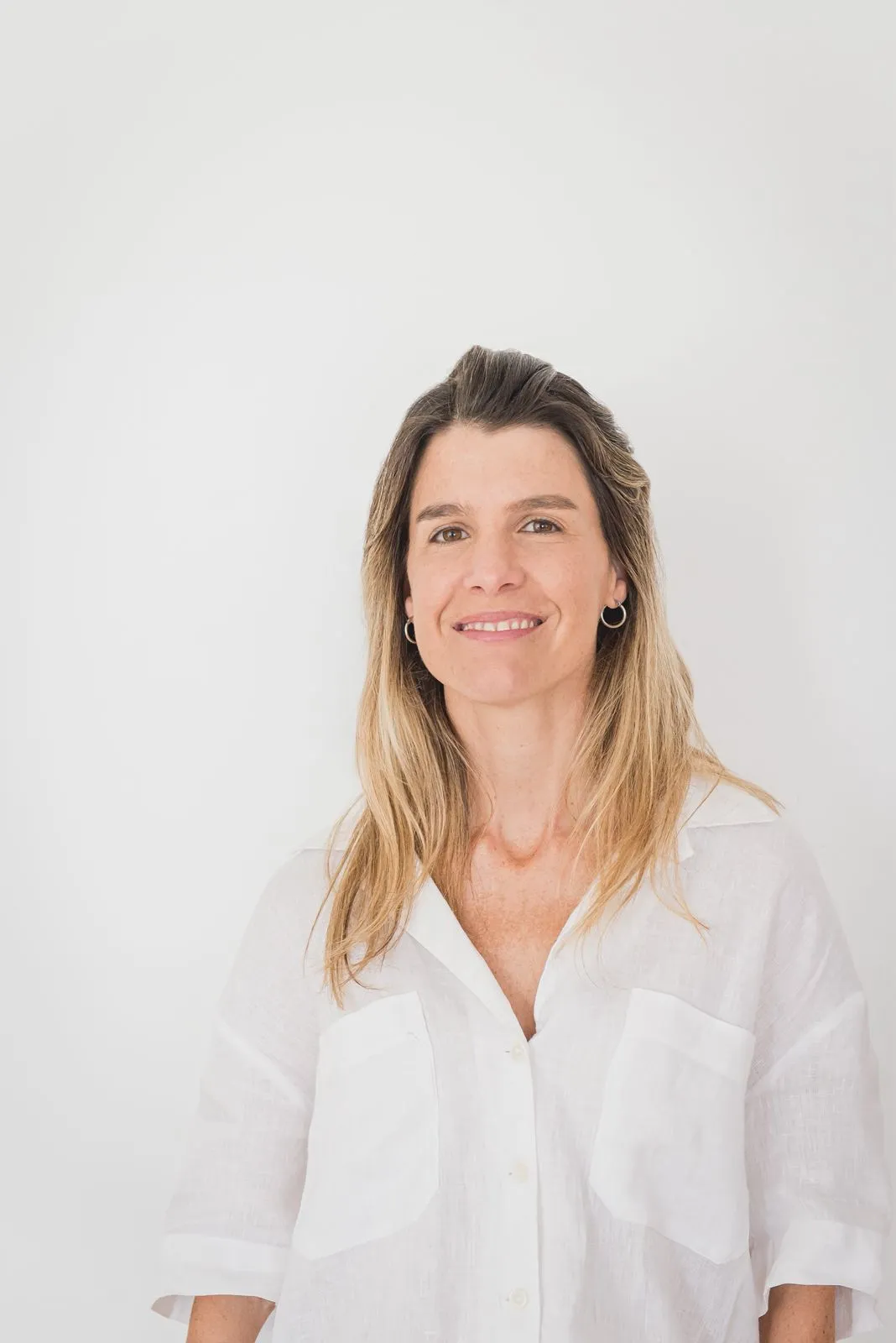 Natalia Goñi con camisa blanca, sonriendo y mirando a cámara