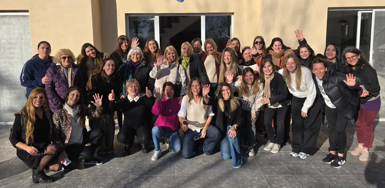 Grupo de mujeres del programa Desde Adentro saludando a cámara en el patio de una casa